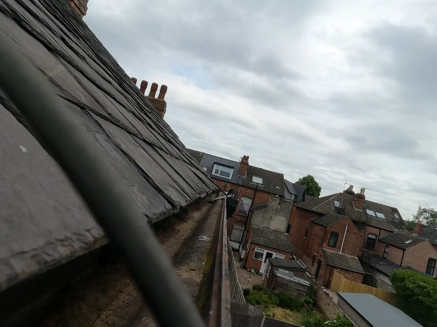 After: rear cast-iron gutter of a Victorian house on Charnwood Grove, West Bridgford, cleared to bare metal below the slate roof