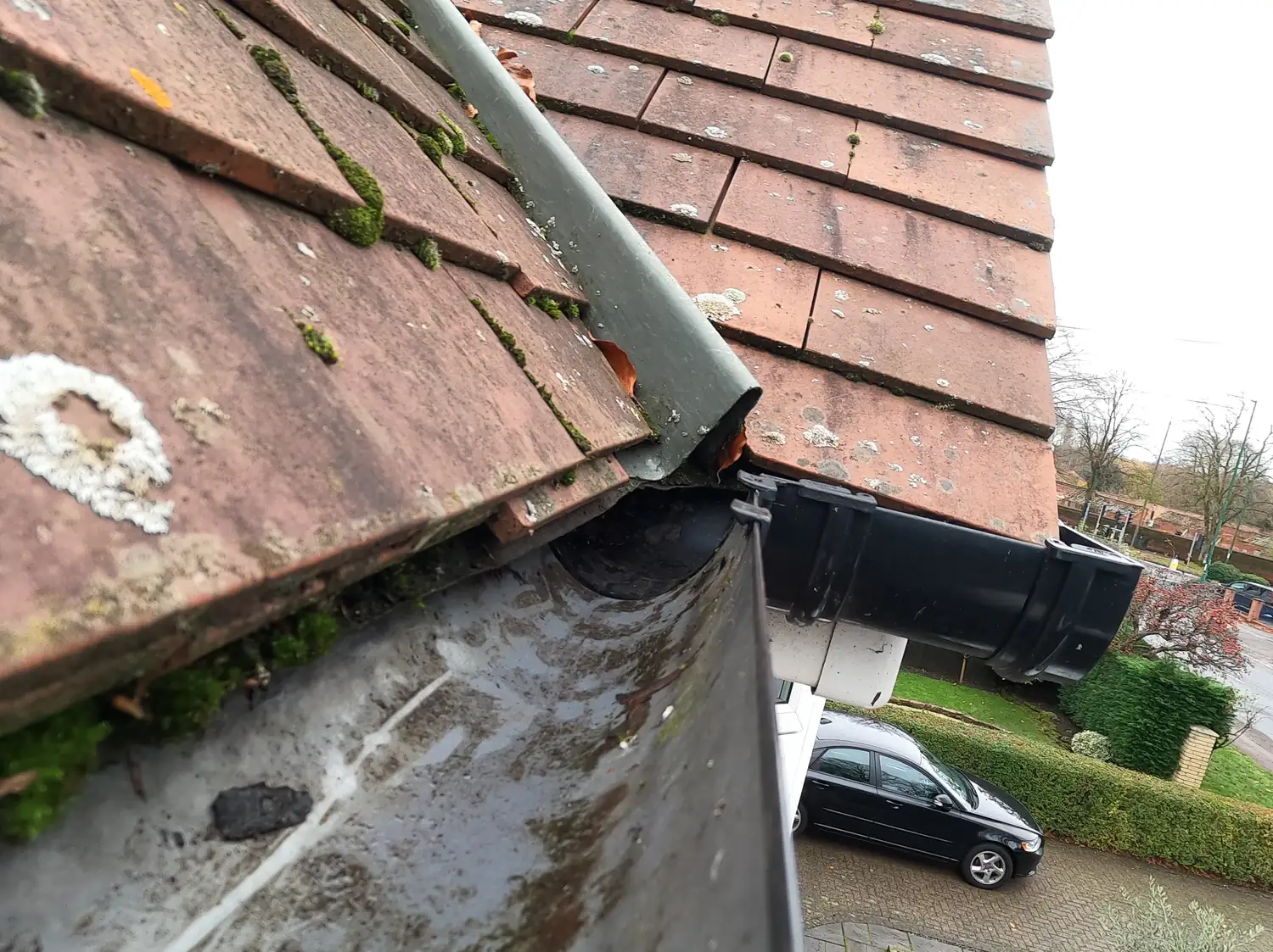 After: front gutter of a clay-tiled house on Russell Drive, Wollaton, cleared to bare metal with the outlet and downpipe open