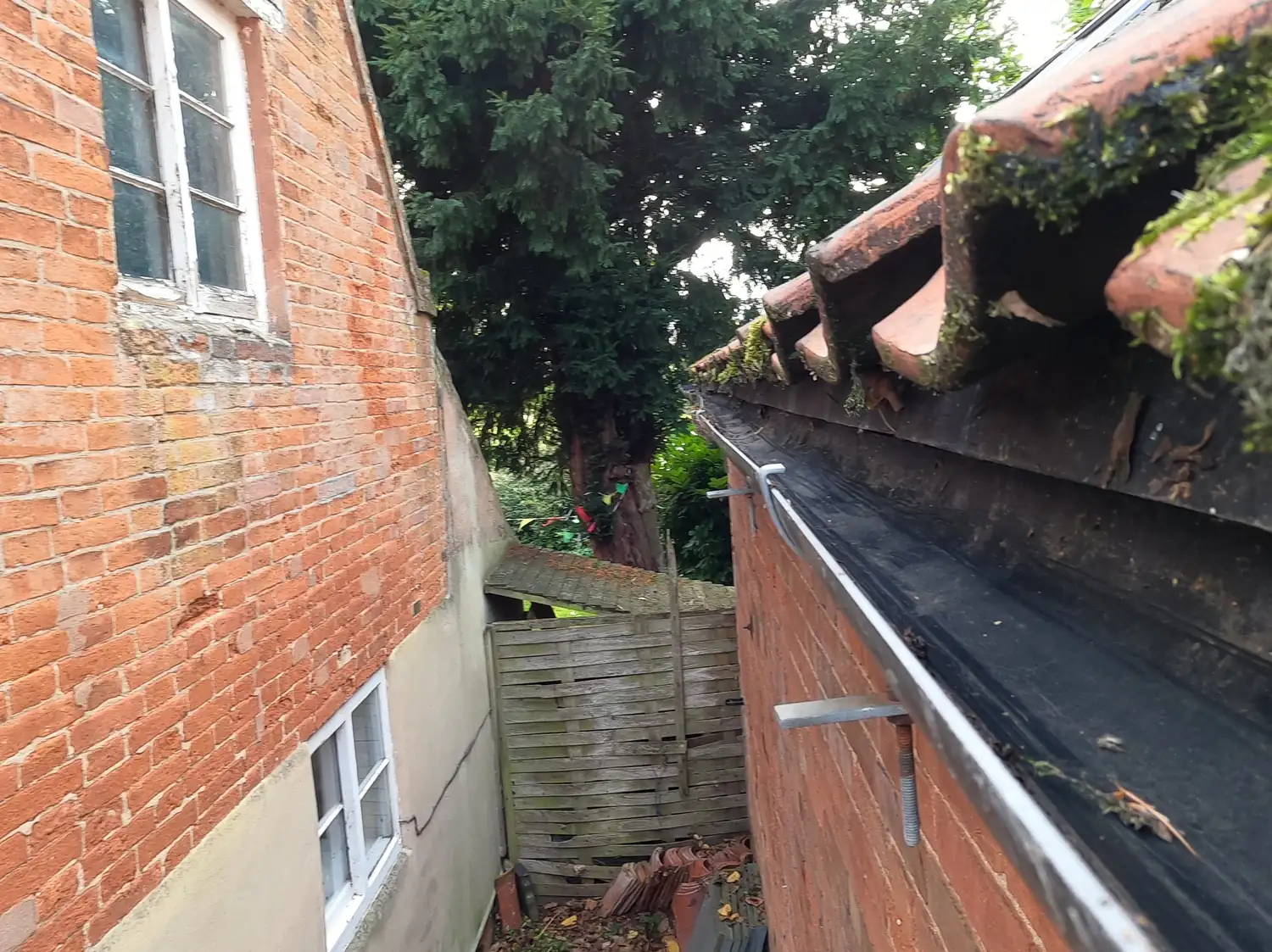 After: gutter on a converted stables in Gonalston, cleared along its full length below the clay pantiles, in the narrow passage between the buildings