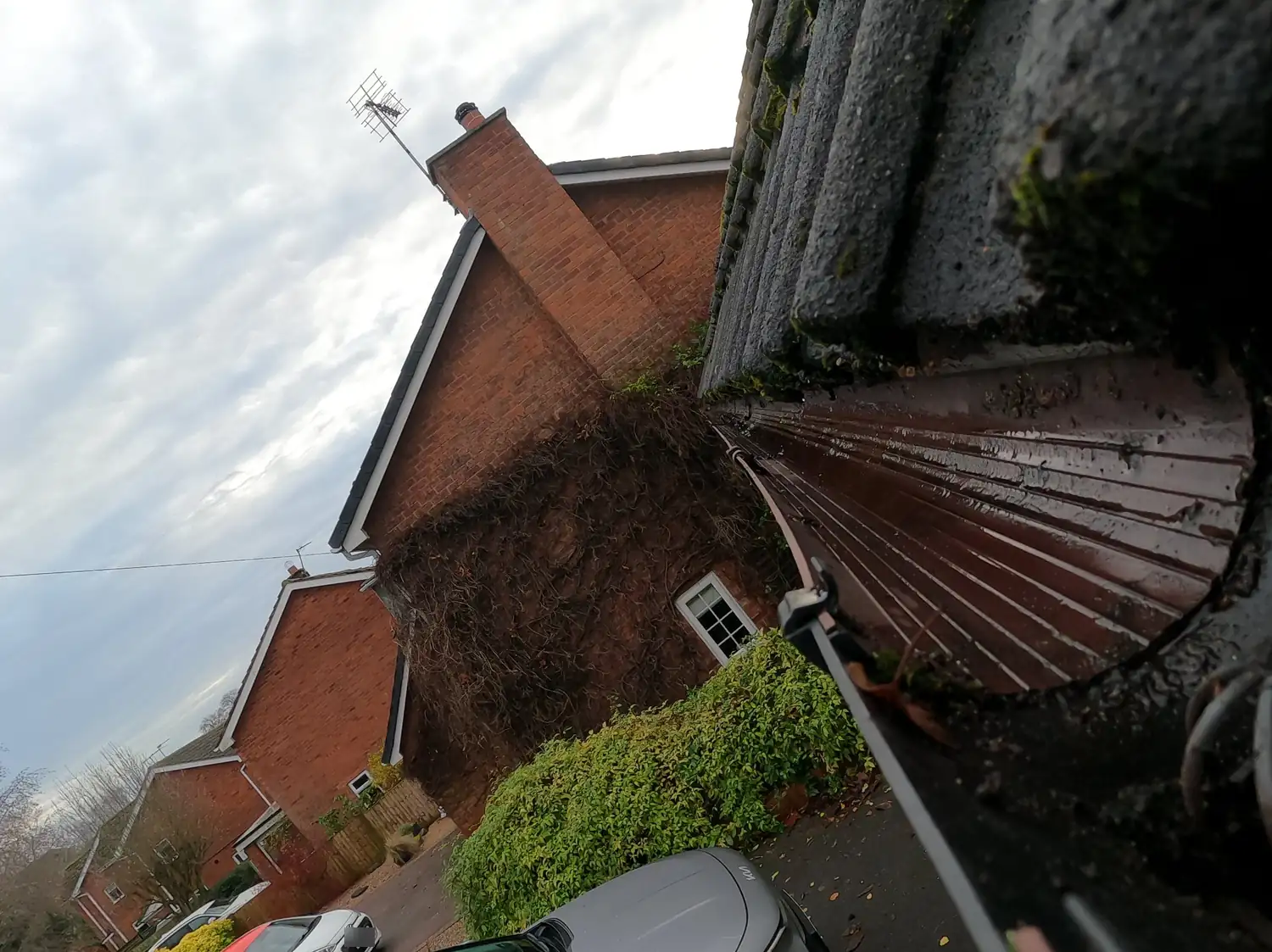 After: front gutter on Padleys Lane, Burton Joyce, cleared to bare metal along its full length, with the chimney and ivy-clad gable behind