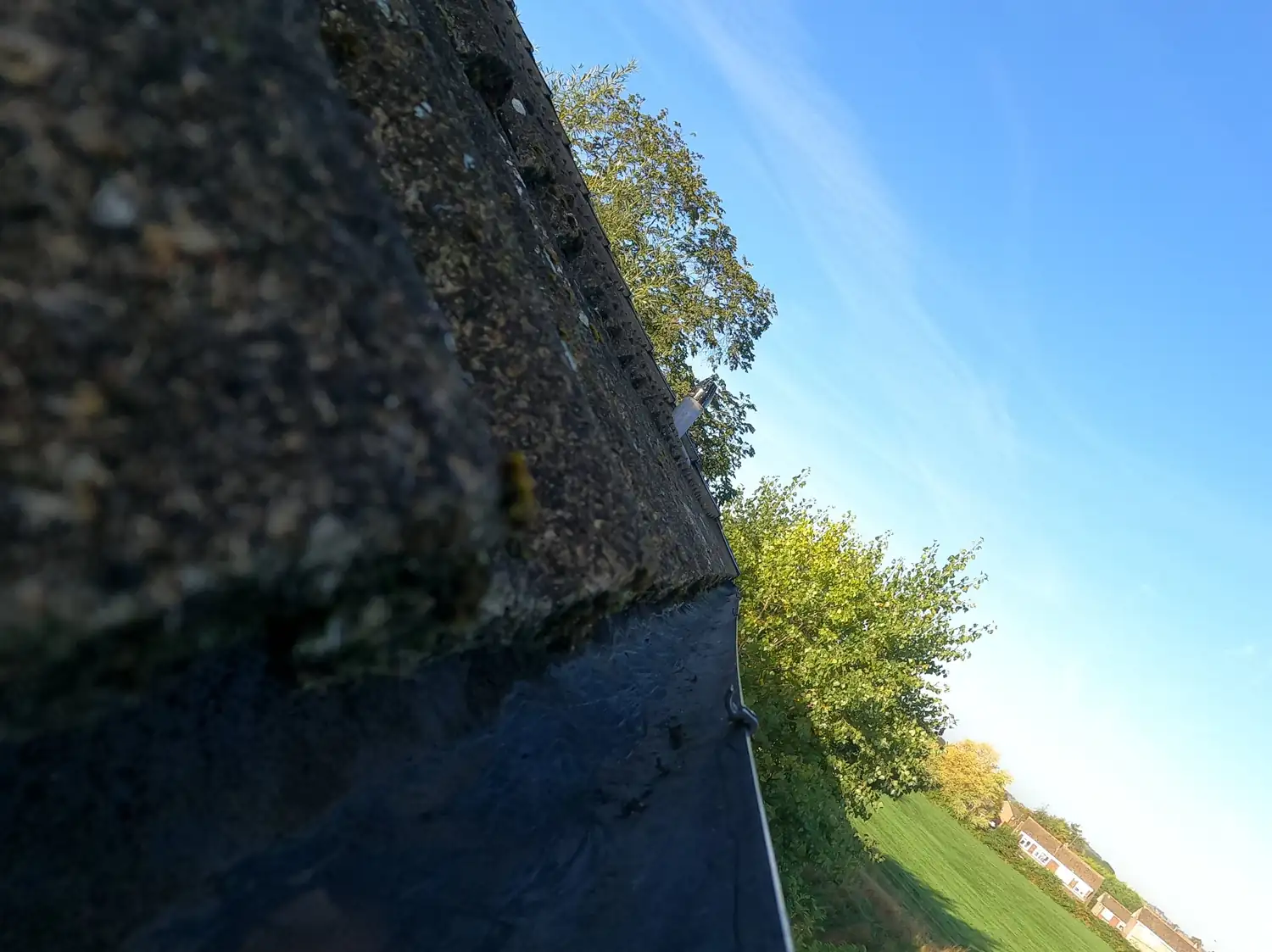 After: rear gutter on Ramsey Drive, Woodthorpe, cleared to bare metal along its full length with the outlet open, fields and trees behind the house