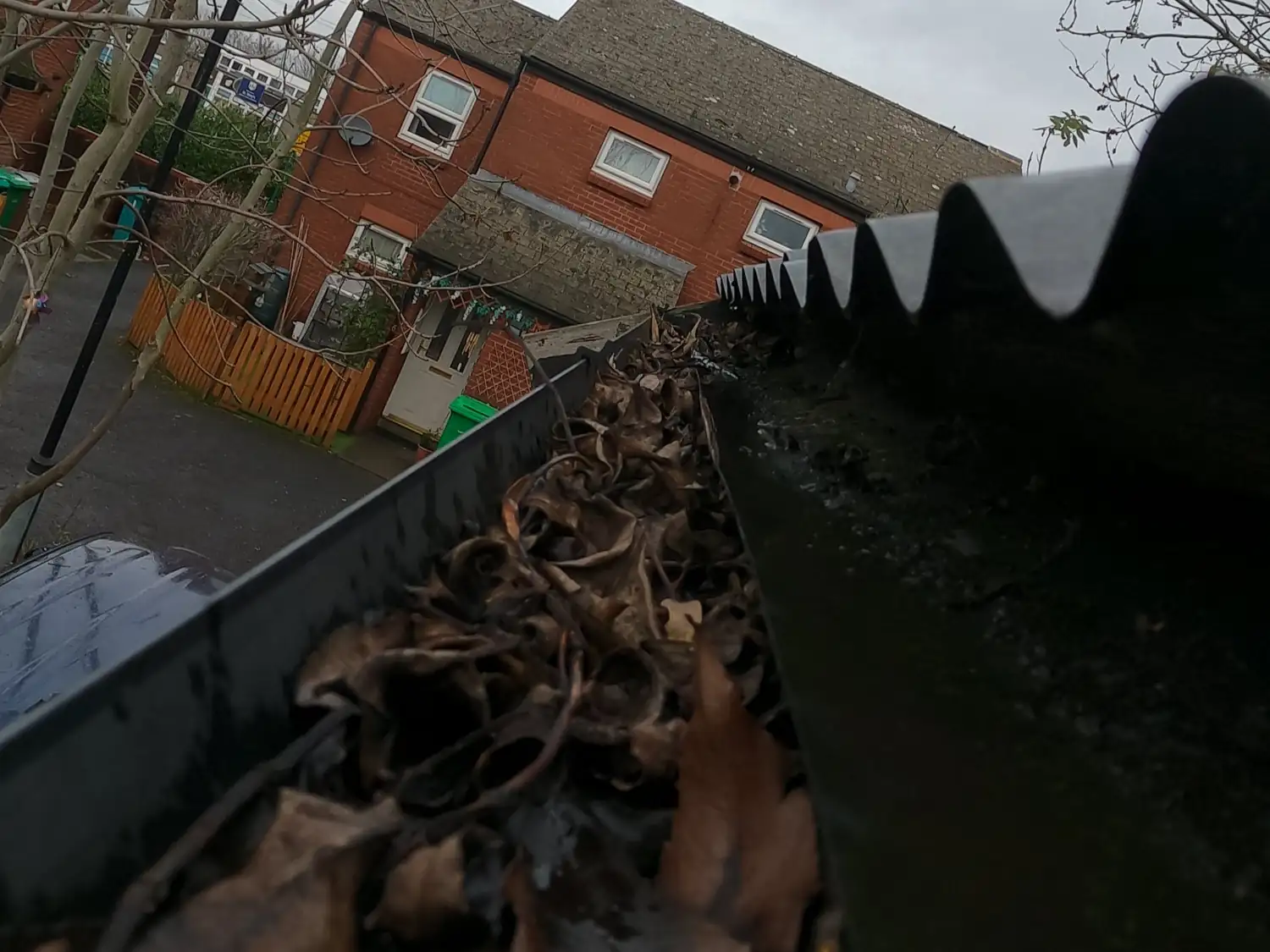 Before: gutter on Fisher Street, Radford, packed with dry leaves below a row of spiked gutter guards